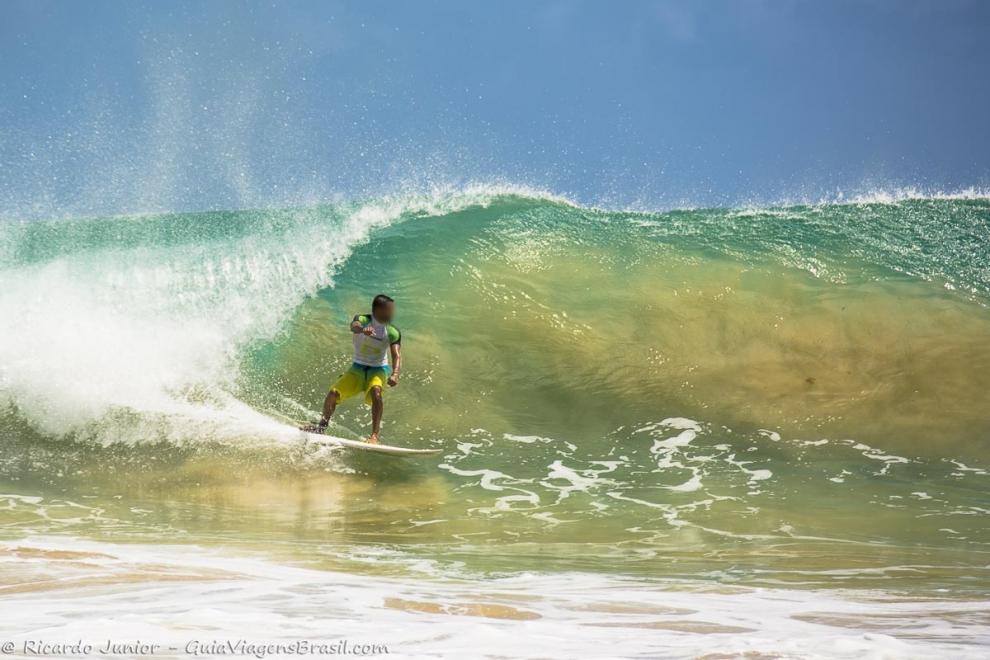 Imagem de um surfista no tubo esperando para executar manobra.